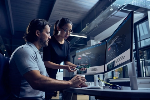 Designers around a computer discussing PCB for ADAS