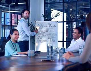 4 business people discussing over flipchart 4 business people discussing over flipchart